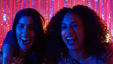 Portrait-Of-Two-Women-Friends-Having-Fun-Dancing-In-Nightclub-Bar-Or-Disco-With-Sparkling-Lights-1